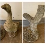 A garden stone tree stump ornament and stone duck ornament