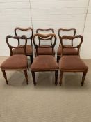 Six balloon back dining chairs on turned legs, two with reeded legs and upholstered seats