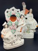 Two Staffordshire figural groups, one with a clock face, the other with a fob watch holder