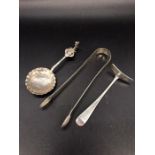 Three silver hallmarked items to include sugar nips, children's food pusher and a spoon.