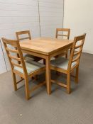 An oak dining/kitchen table with extending sides and four chairs
