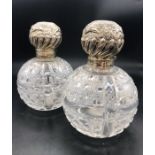 A Pair of Large Cut Glass Scent Bottles with ornate silver tops, hallmarks rubbed.