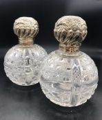 A Pair of Large Cut Glass Scent Bottles with ornate silver tops, hallmarks rubbed.