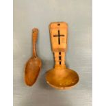 Two carved wooden spoons one with religious theme