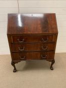 A mahogany bureau with hinged drop down writing slop, opening to reveal an assortment of drawers and