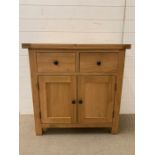 Small pine sideboard with two drawers above a pair of hinged doors (H85cm W85cm D38cm)