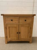 Small pine sideboard with two drawers above a pair of hinged doors (H85cm W85cm D38cm)