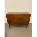 A drop leaf table on turned leg supports and castors (H73cm W90/127cm)