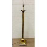 A Floor standing brass column light on lion claw feet.