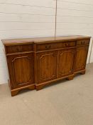 A Yew wood sideboard with double doors to centre flanked by single cupboards and three drawers H87cm