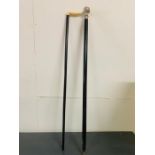 A pair of walking sticks, one with bone handles another with inset compass