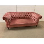 Two seater pink Chesterfield sofa. (H75cm D84cm W180cm)