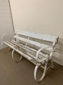 19th century Victorian garden bench with cast iron scrolled sides and wooden slats to seat and back,