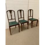 Three mahogany dining chairs with green seat