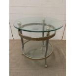 A glass and white metal circular table of modern design