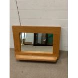 An oak wall mirror with shelf