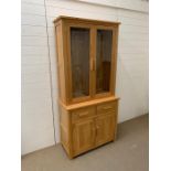 An oak glazed display unit with cupboard under (H195cm W92cm D43cm)