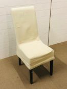 A modern chair in cream with a cream linen chair cover
