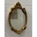 Oval gilt mirrors with cherubs to frame