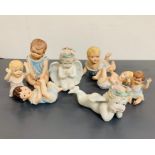 Eight china cherubs of various sizes