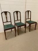 Three mahogany dining chairs with green seat pads