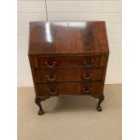 A mahogany bureau with hinged drop down writing slop, opening to reveal an assortment of drawers and