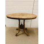 An walnut oval side table on four turned supports (H75cm W97cm D54cm)