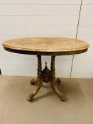 An walnut oval side table on four turned supports (H75cm W97cm D54cm)