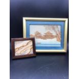 A framed 3D picture of a sea and mountain scenery and a framed miniature of the mountains