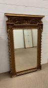 Regency giltwood mirror with scrolling floral decoration to top (H124cm W71cm)