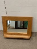 An oak wall mirror with shelf