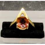 An 18 ct gold ring with central amber coloured stone