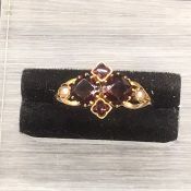 A Pearl and Garnet ring on a gold setting