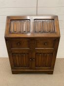 An oak bureau with four carved panels to front AF (H100cm W77cm D44cm)