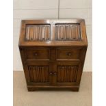 An oak bureau with four carved panels to front AF (H100cm W77cm D44cm)