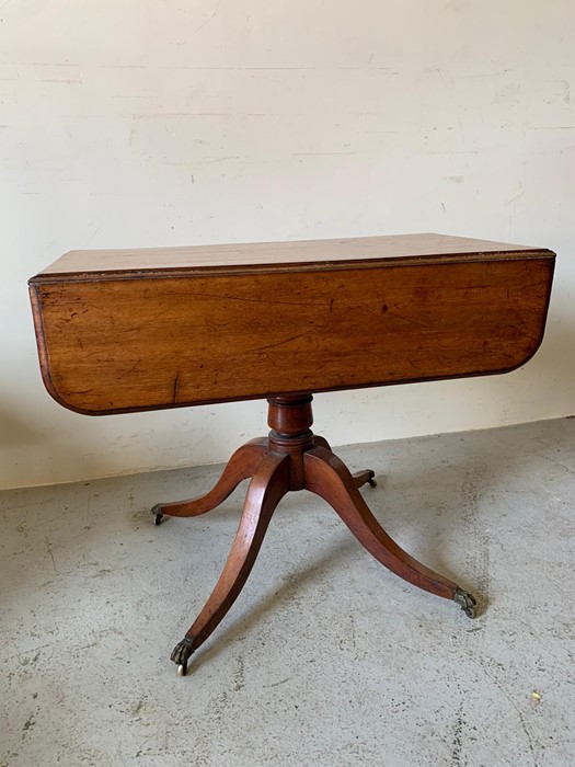 A Regency Pembroke table on four down swept legs and brass claw feet (90cm x 86cm x 68cm)