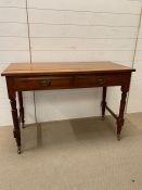 A Hall table with two drawers on turned legs with brass castors (H44cm W108cm D48cm)