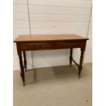 A Hall table with two drawers on turned legs with brass castors (H44cm W108cm D48cm)