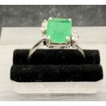 An Emerald ring with diamond shoulders on white gold band marked 750