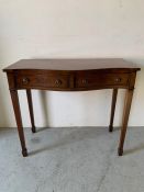 Mahogany serpentine side table with two drawers on tapering legs (H86cm W100cm D44cm)