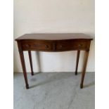 Mahogany serpentine side table with two drawers on tapering legs (H86cm W100cm D44cm)