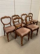 Six balloon back dining chairs on turned legs and upholstered seats