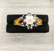 An 18 ct yellow gold Daisy style ring with central diamond and six sapphires (4.2g)