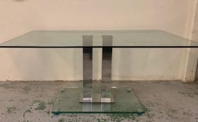 A Glass Dining Table on central metal pillars support 160 cm L x 90 cm W x 76 cm H.