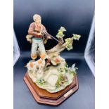 A Capodimonte figure of a hunter and dog with a duck
