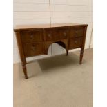 A dressing table on turned legs and four drawers to front (H77cm W115cm D55cm)