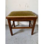 A mahogany stool with green upholstery
