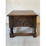 An oak stool with hinged top and carved sides (H43cm W43cm D33cm)