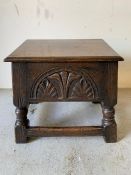 An oak stool with hinged top and carved sides (H43cm W43cm D33cm)