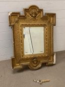 Carved and giltwood wall mirror, in the manner of William Kent. The frame centered with a cherub